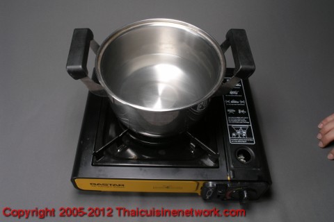 ล้างปลาให้สะอาด ขอดเกล็ดควักไส้ทิ้ง นำน้ำ 2 ถ้วย ใส่หม้อตั้งไฟ