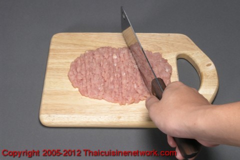 นำเนื้อหมูสับ คลุกกับเกลือ น้ำมะนาว แล้วบีบเอาน้ำออก